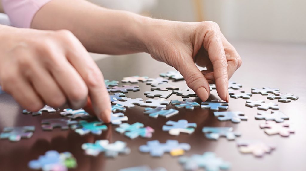 Adult Day Care services means more than a place to stay for hours at a time, DaySpring has a multitude of services that keep older adults engaged. A woman piecing together a puzzle.